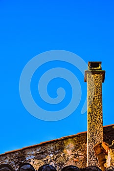 Tall concrete, chimny with a flat metal top,on side of a building in a village in Provence, Francd