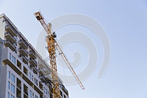 Tall construction crane, construction of a residential skyscraper