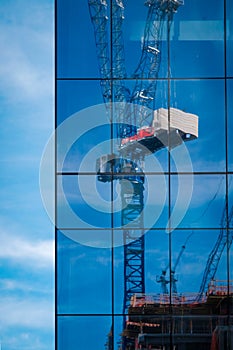 Tall crane reflected in mirrored windows of skyscraper in Charlotte, North Carolina