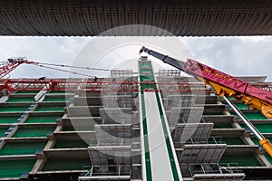 Tall cranes and construction workers