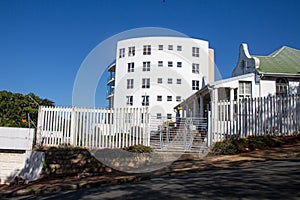 Tall Curved White Residential Building Against Blue Sky