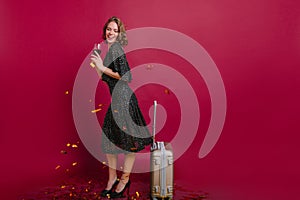 Tall elegant girl celebrating vacation with wine and laughing. Indoor full-length portrait of female model with short