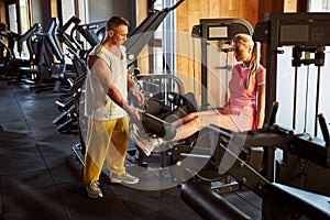 Tall fit lady using leg extension machine at the gym