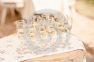 Tall flutes filled with champagne or a bubbly alcoholic drink set on a table ready to be served to the guest