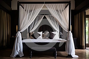 a tall four-poster bed with a blackout canopy