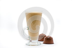 A tall glass of coffee latte or cappuccino and generic coffee pods