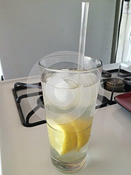 Tall Glass of Icy Cold Lemon Water in the Kitchen on a Hot Day