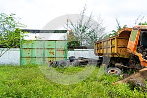 A tall green iron door standing still with a broken tuck on the side of the frame