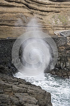 Tall gush of ocean water on volcanic cliffs at Porto de Cruz, Madeira