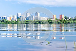 Tall houses are reflected in the water