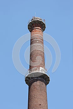 Tall industrial chimney on a blue sky with copy space for your text