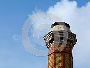 Tall industrial chimney stack of yellow and red brick of octagonal base