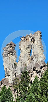 rock formation under blue sky and forest