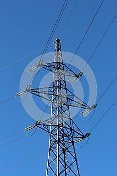 Tall large power line utility pole with seven electrical wires connected with long transparent glass insulators