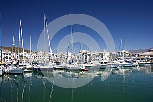 Tall luxury boats and yachts moored in Duquesa port in Spain on