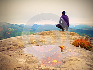 Tall man in black on cliff and watch to mountain sunrise.Silhouette