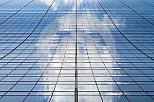 Tall modern skyscraper building with clouds reflected in the glass windows in Manhattan New York City