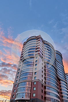 Tall modern skyscraper with a unique shape shot on the sunset, copy space above