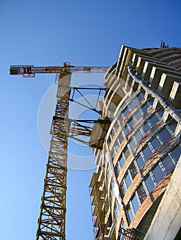 Tall orange crane constructing a new business building