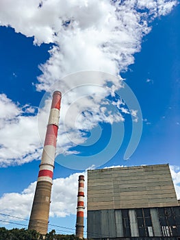 Tall pipes of a plant against a blue sky