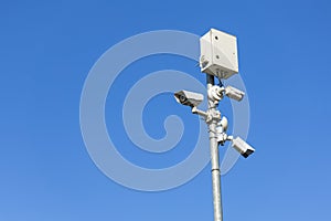 A tall pole with three security cameras