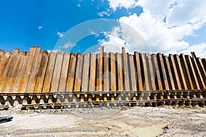 Tall rebar iron elements form a dividing and supporting wall on a hillside construction site