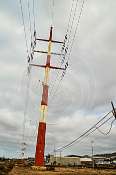 A tall red and white pole with wires coming out of it