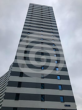 Tall residential building in the form of a column of blue and white color in the city center. there are many small rectangular