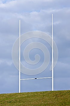 Tall rugby goal posts and blue clouds