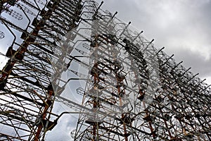 Tall rusty edifices featuring a complex network of wires. Duga is a Soviet over-the-horizon radar station for an early detection