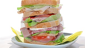 Tall sandwich with ham, chicken, cheese and tomato