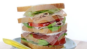 Tall sandwich with ham, chicken, cheese and tomato