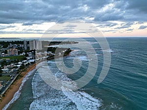 tall seaside residential buildings Luquillo, Puerto Rico (aerial drone view) downtown waves beach, mountains el yunque photo