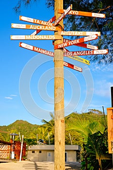Tall sign post pointing directions to cities and towns around Cook Islands and world