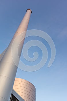 A tall silver chimney against blue sky