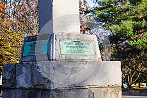 A tall slender stone monument to James Robertson the founder of Nashville on the edge of the lake