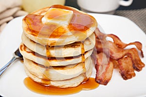 Tall stack of pancakes with bacon