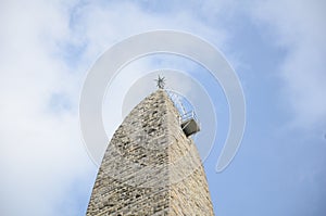 tall stone building or tower with clouds in sky