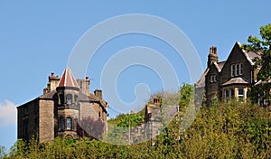 Tall stone gothic houses set in the woodland landscape i hebden bridge west yorkshire with blue sky