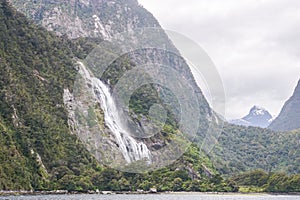 tall waterfall from the mountain at Milford Sound in New Zealand