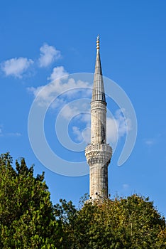 A tall white minaret of a Muslim mosque