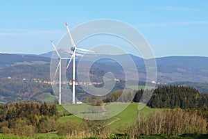Tall wind power plants in spring landscape