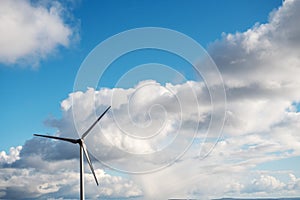 Tall wind power turbine against cloudy sky. Renewable green energy production, source of clean electric supply