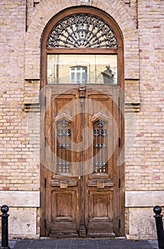 tall wooden door of an old building historic house with exposed brick facade