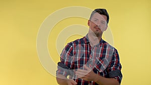 Tall young man deriding somebody, making fun of someone on yellow background.