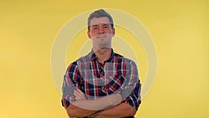 Tall young man deriding somebody, making fun of someone on yellow background.