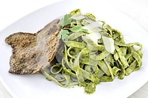 Tallarin Verde con Bistec is a famous Peruvian dish. It is Pesto spaghetti with crumbed steak. photo