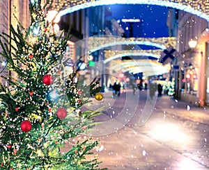 Tallinn City Christmas tree  snowy street in medieval Tallinn old town night  people walk ,snowflakes and night blurred light  ,t