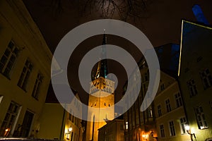 Tallinn, Estonia: Church of St. Olaf. The Church spire is illuminated. Old town with houses at night