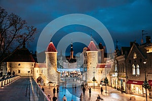 Tallinn, Estonia. People Walking Near Famous Landmark Viru Gate In Street Lighting At Evening Or Night Illumination